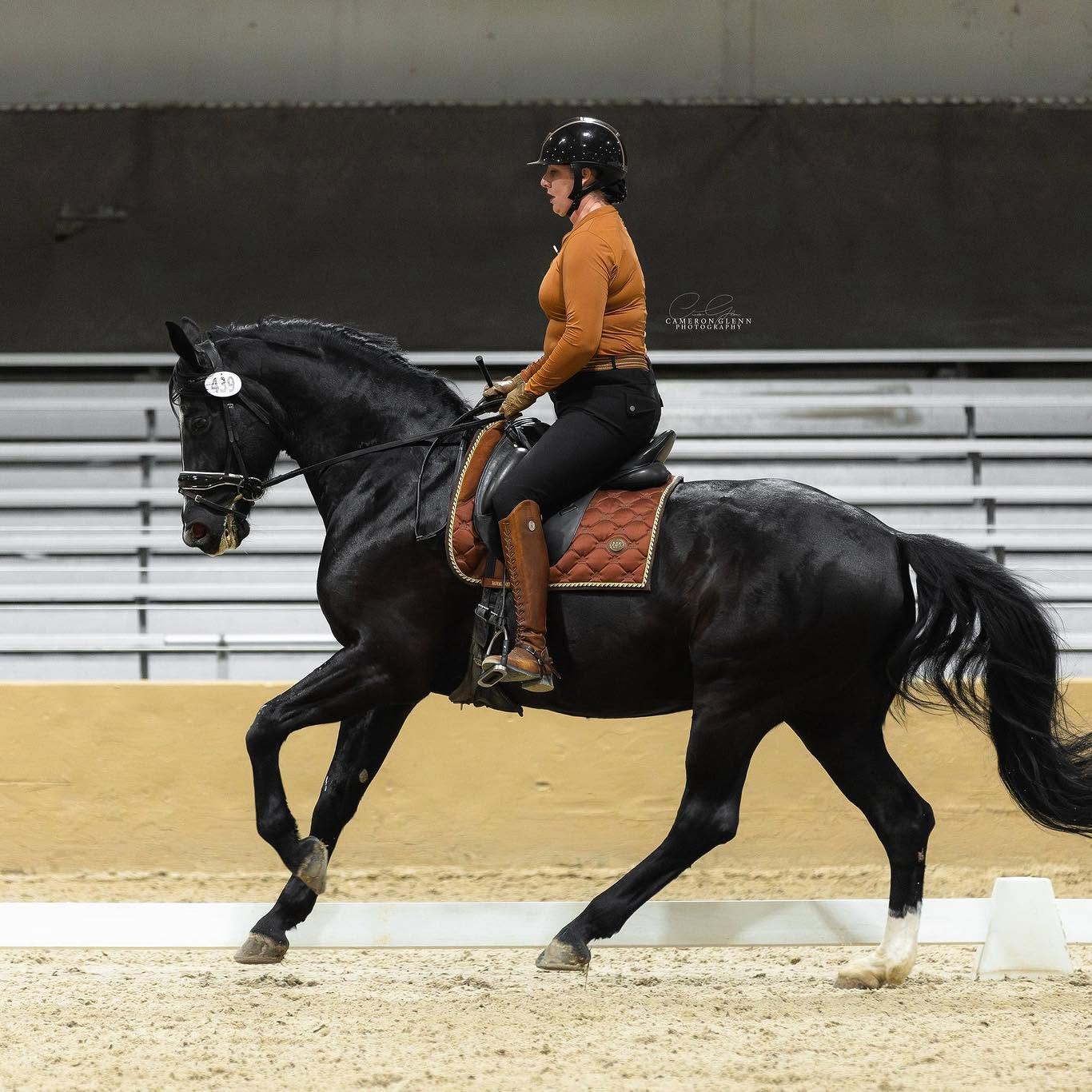 Kylee Matheny riding a black horse in a western dressage class